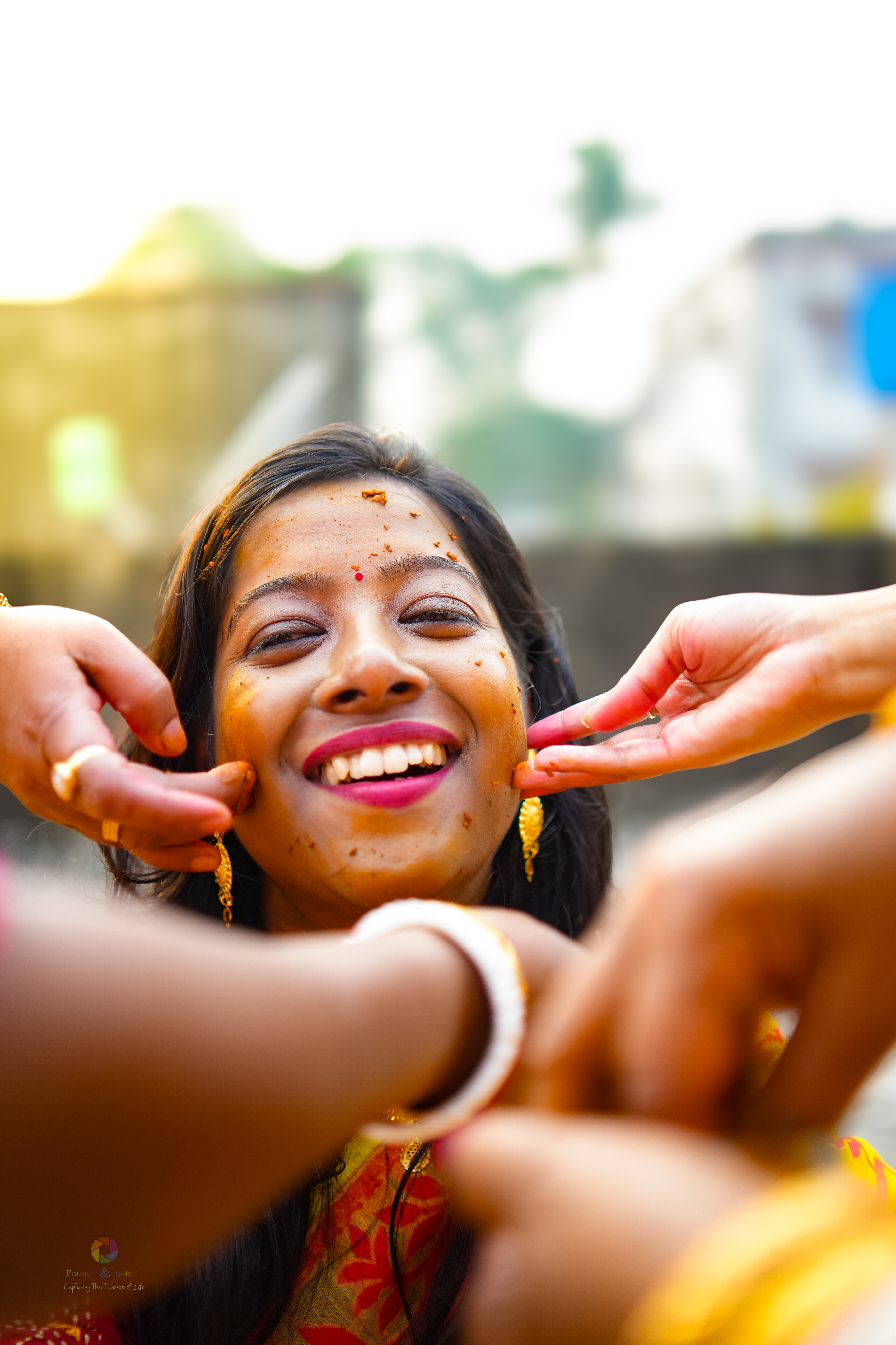 Woman smiling during Haldi ceremony - Candid captured by Frames and Colors photography service